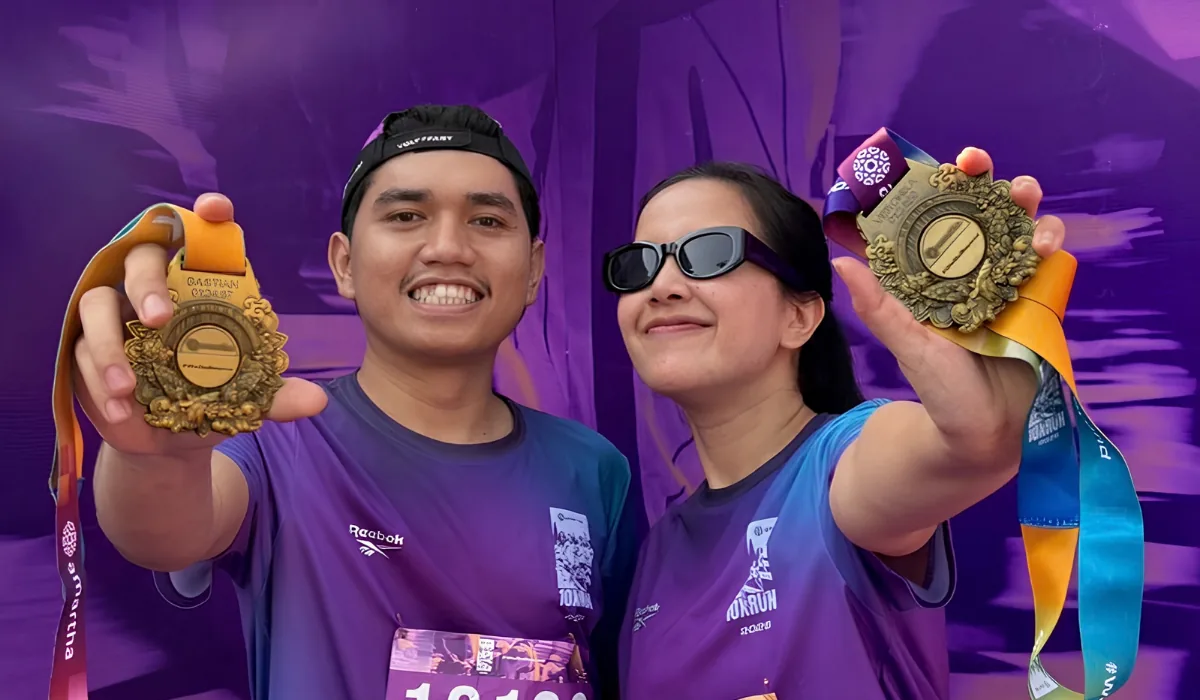 Bastian and Vero holding up race medals after a run
