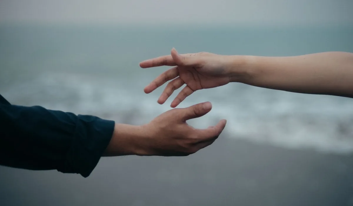 Two hands reaching for each other, almost there
